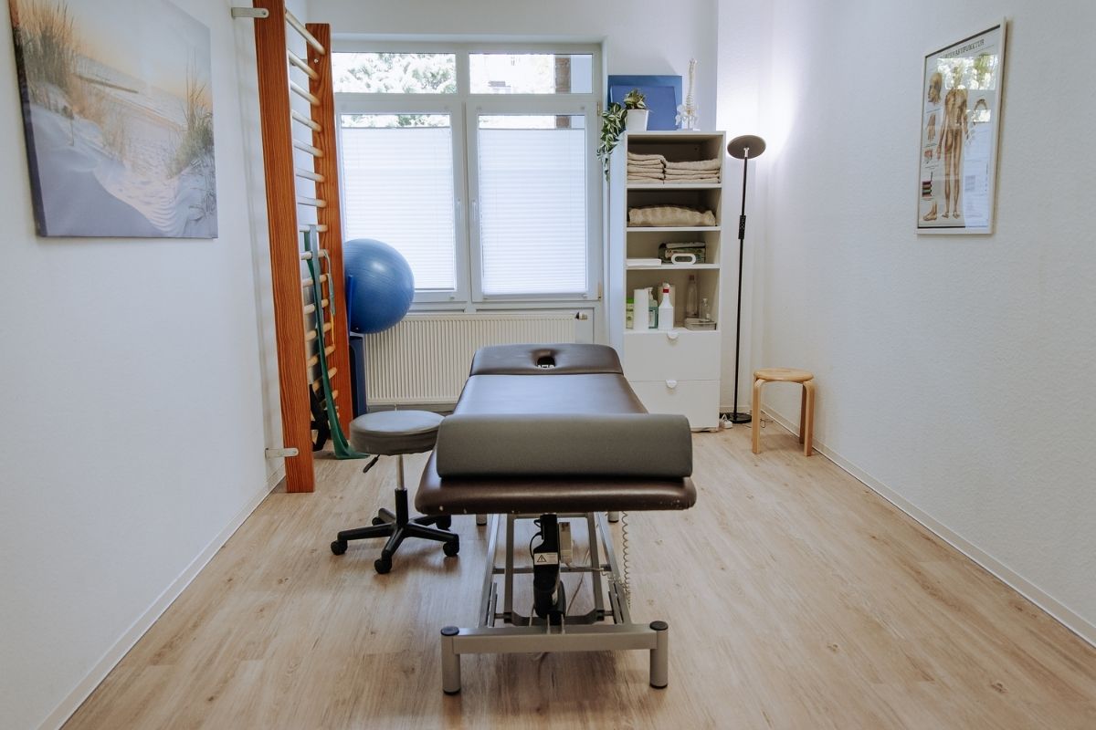 Behandlungsraum der Praxis im Riemekeviertel mit Therapieliege und Trainingsgeräten