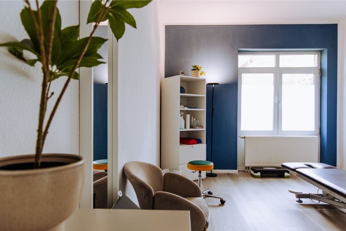 Moderner Behandlungsraum der Praxis im Riemekeviertel mit Therapieliege und Trainingsbereich