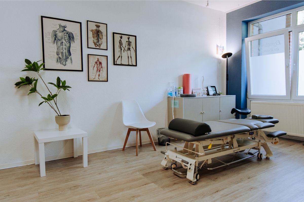 Moderner Therapieraum der Praxis im Riemekeviertel mit Behandlungsliege und anatomischen Bildern